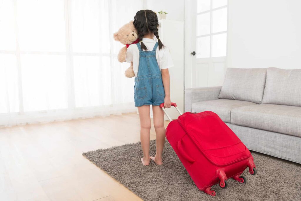 photo of young child with suitcase about to go on holiday